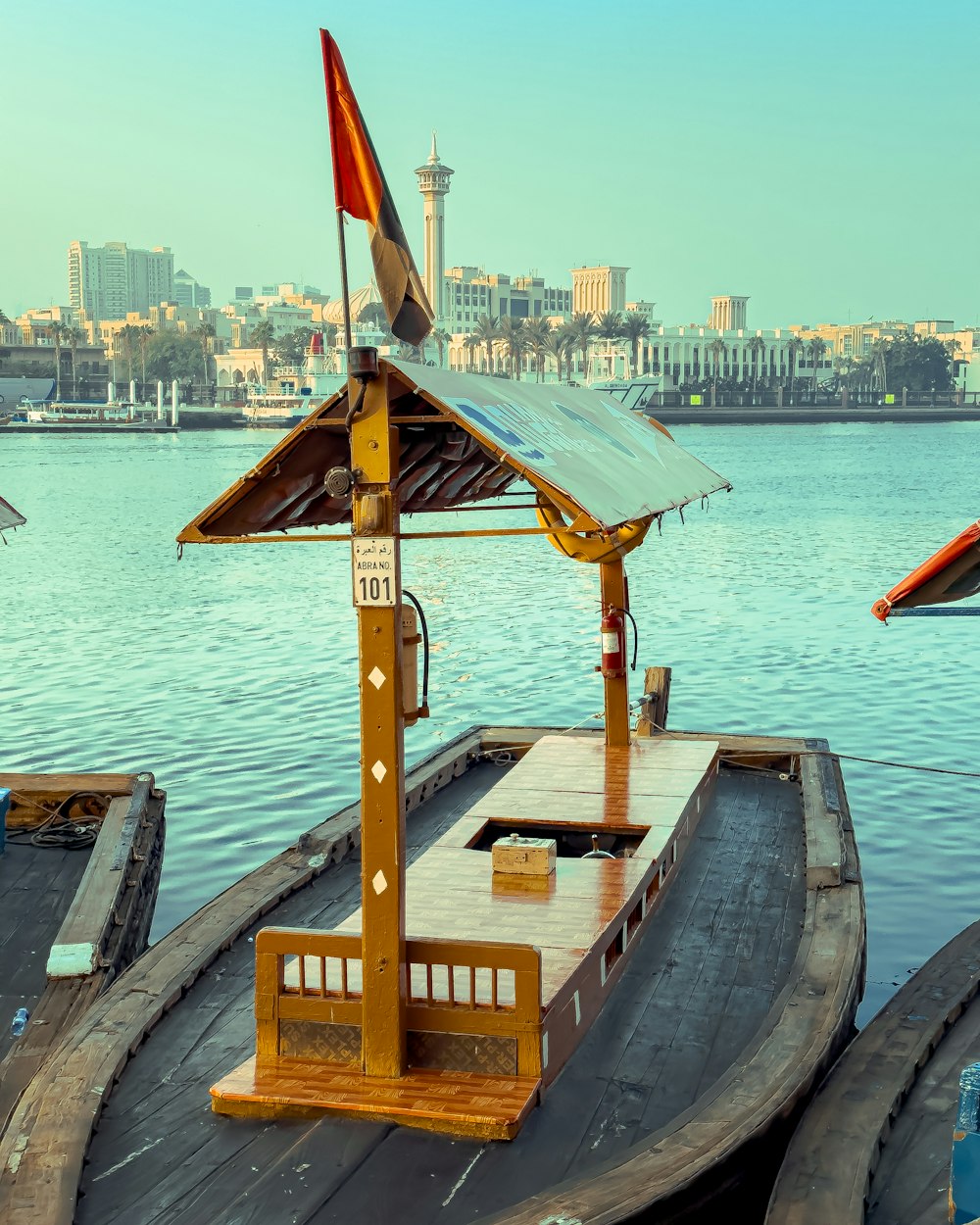 a dock with a small shelter and a small building in the background