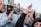 A group of people applauding at a political rally.