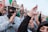 A group of people applauding at a political rally.