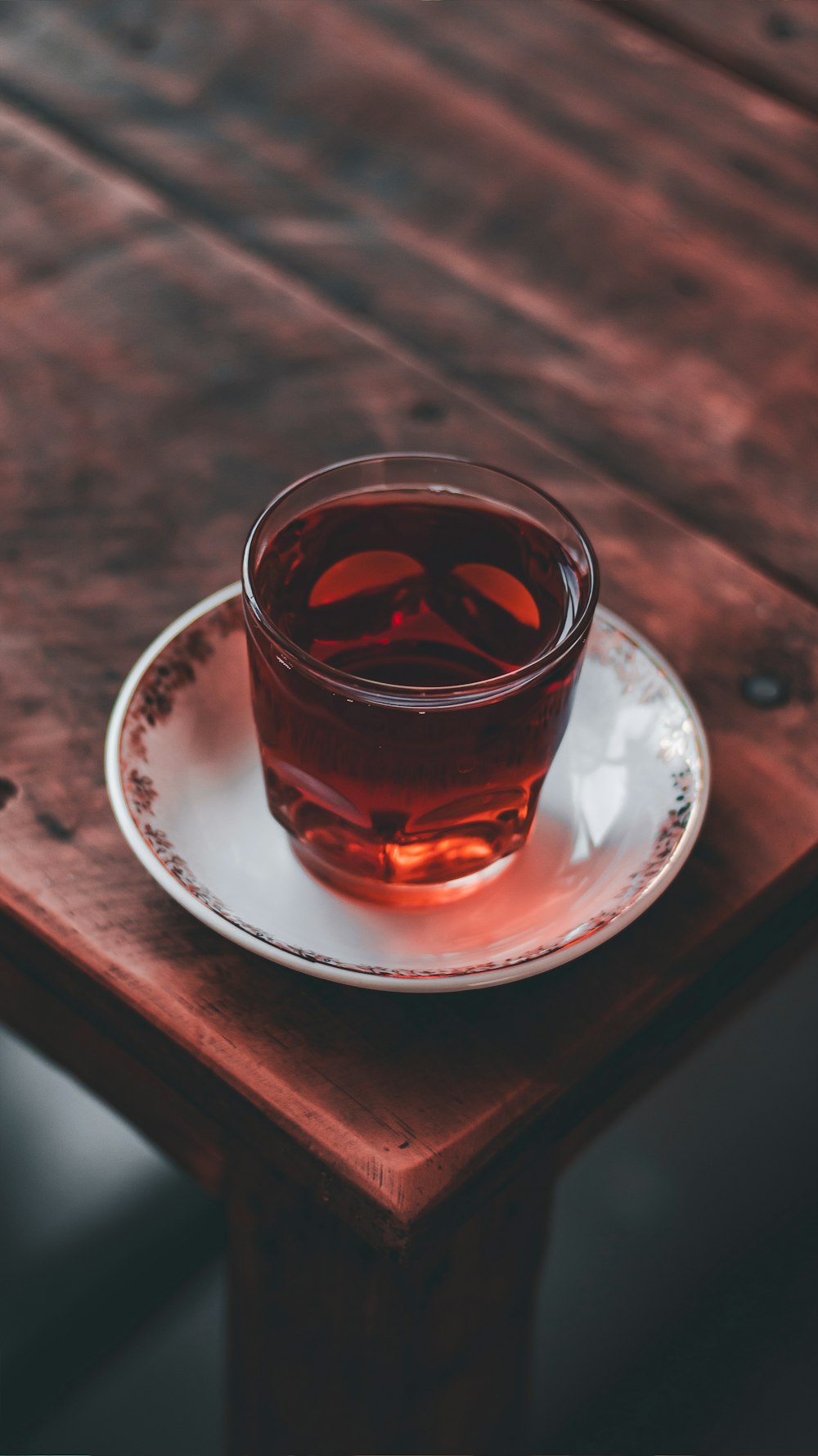 a glass of liquid on a coaster