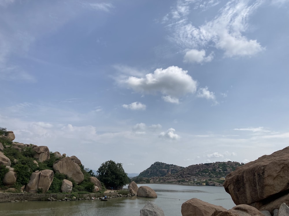 a body of water with rocks and trees around it