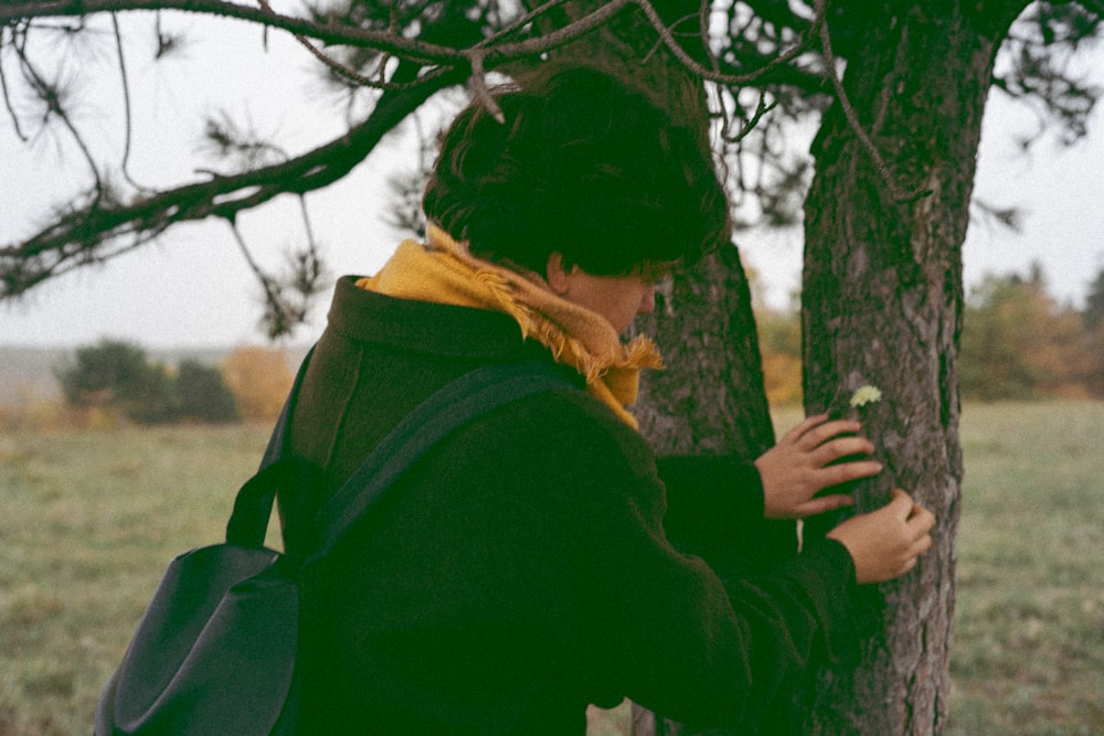 a person in a green shirt holding a tree branch