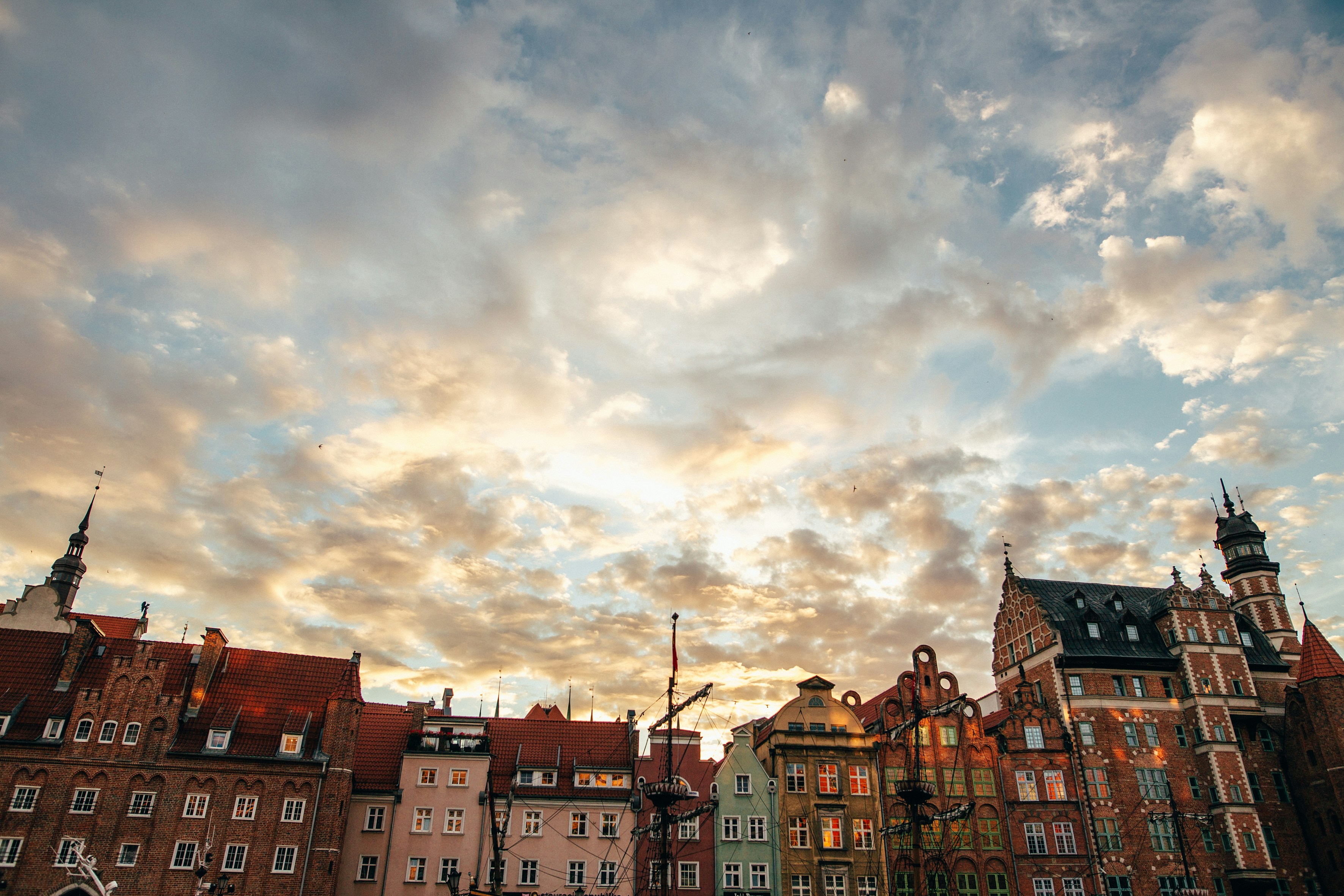 a group of buildings with clouds above, 