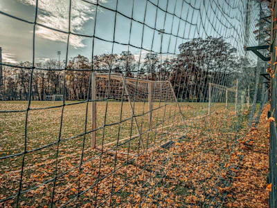 An aerial perspective of a sprawling college soccer field surrounded by autumn trees.
