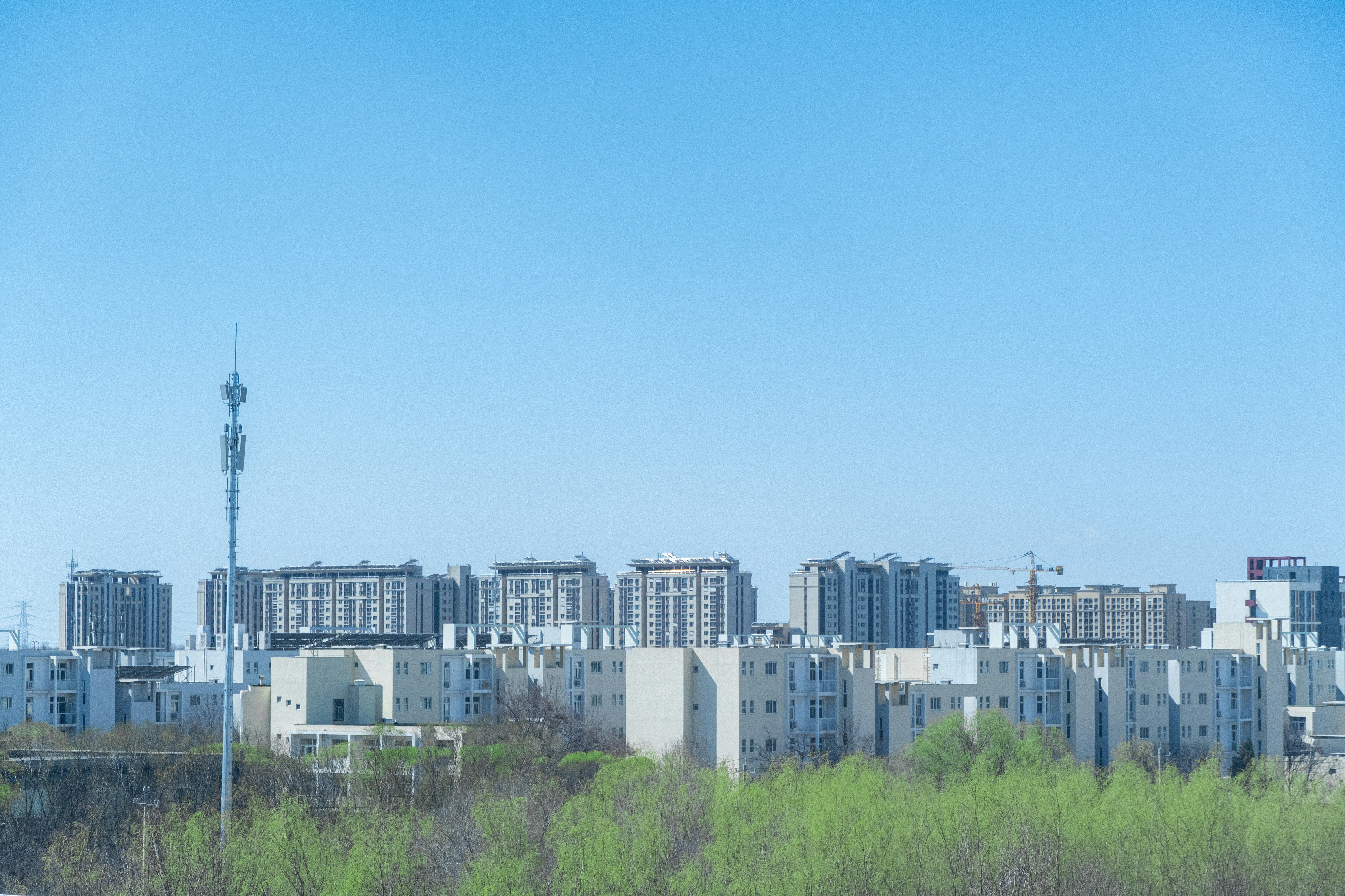 Modern telecommunications tower and network infrastructure against bright blue sky