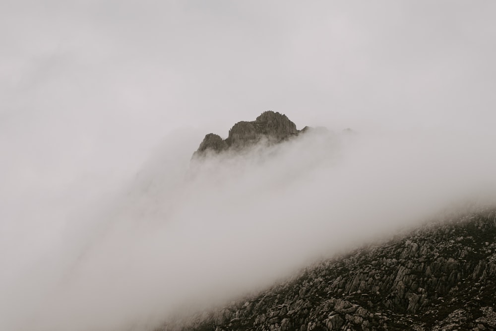 a foggy mountain with a rock formation