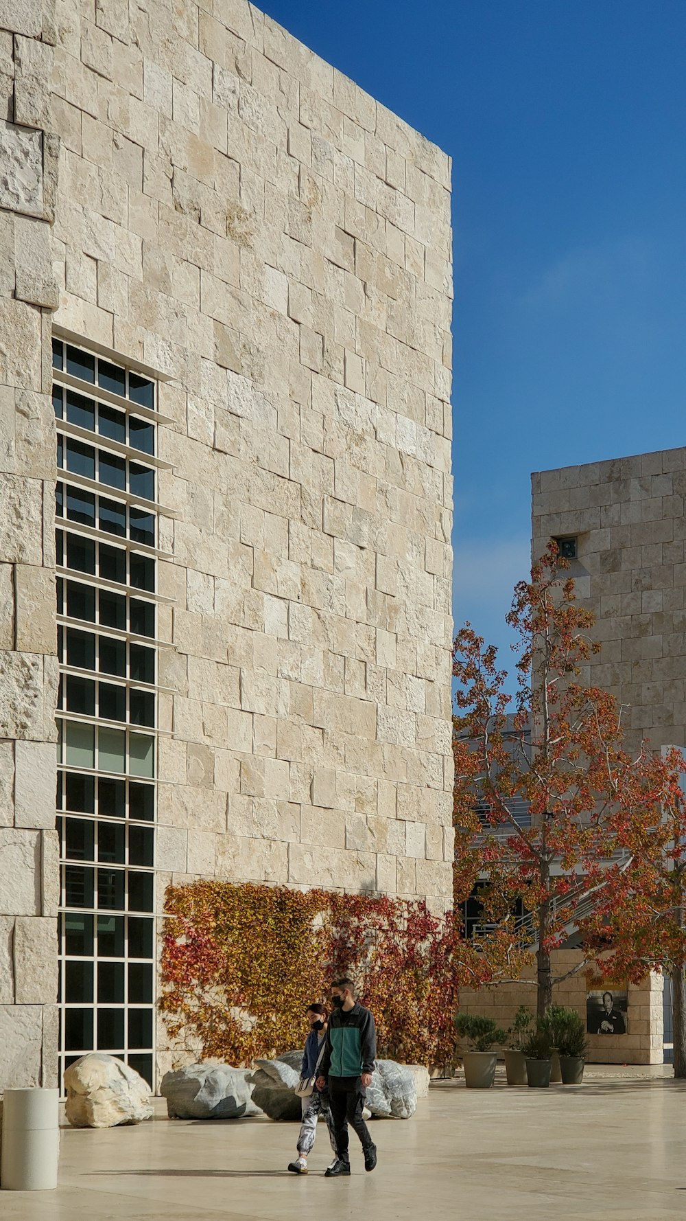 a man and woman walking by a tall building