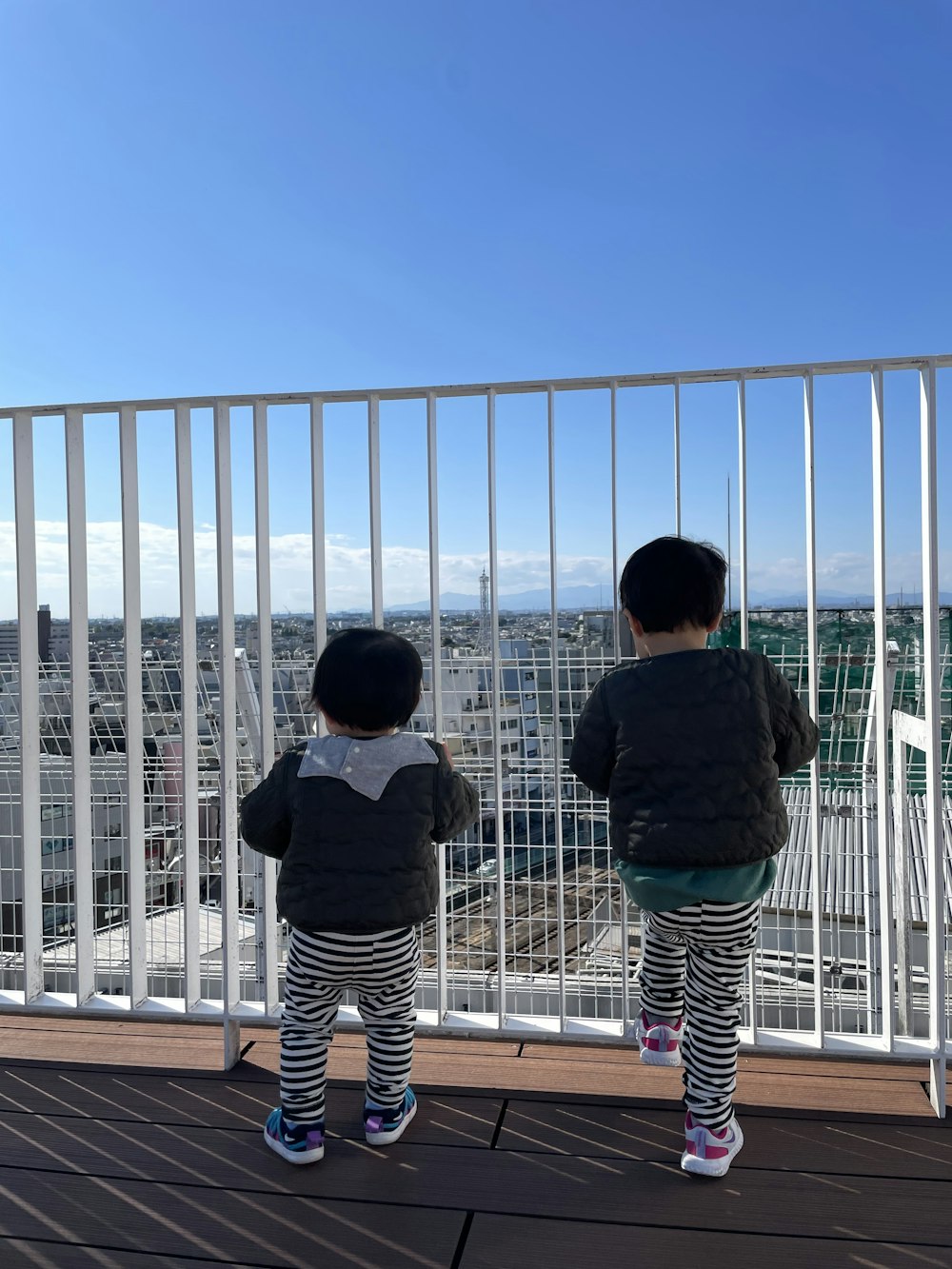 two children standing on a deck