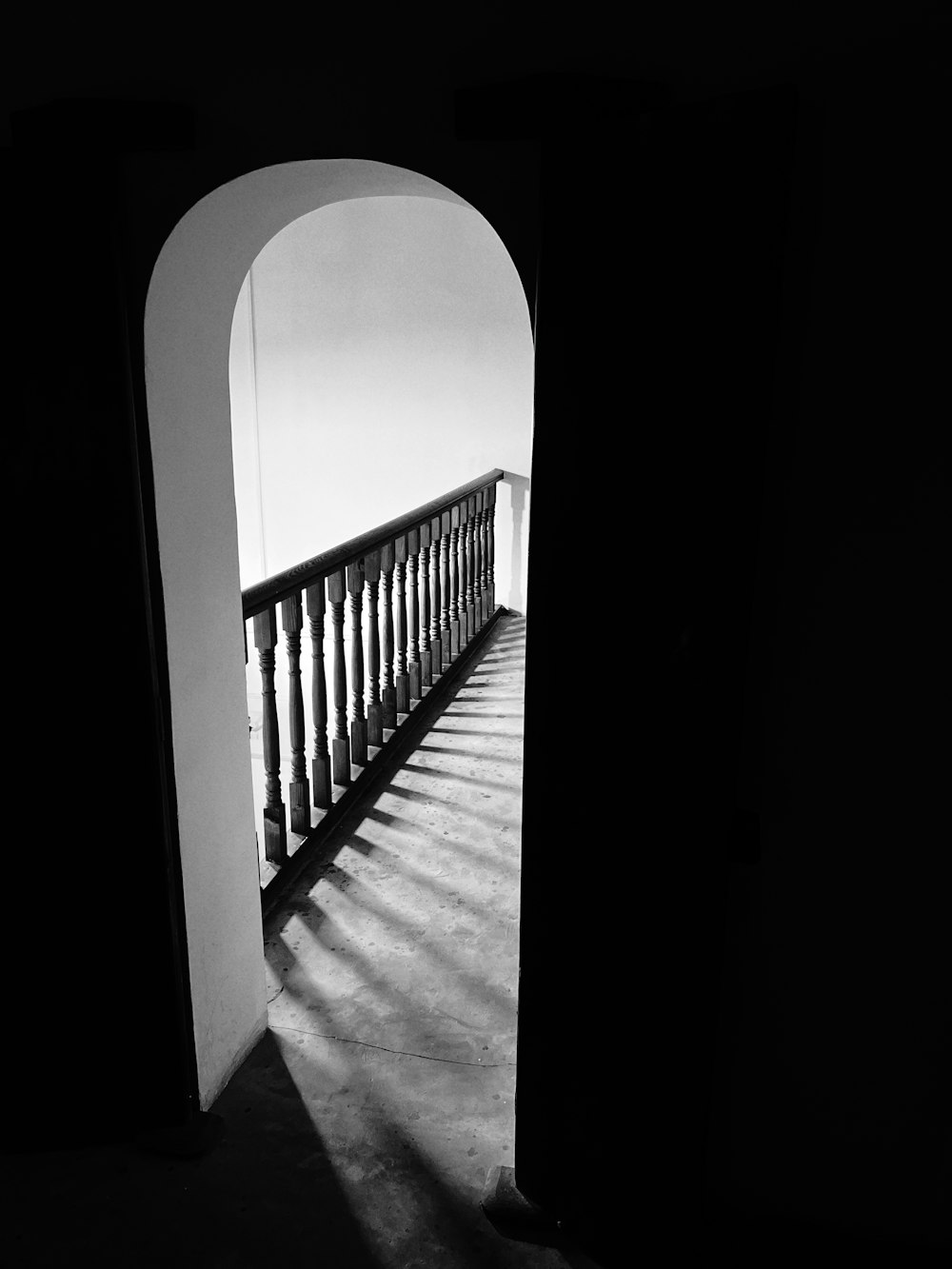 a dark hallway with a railing