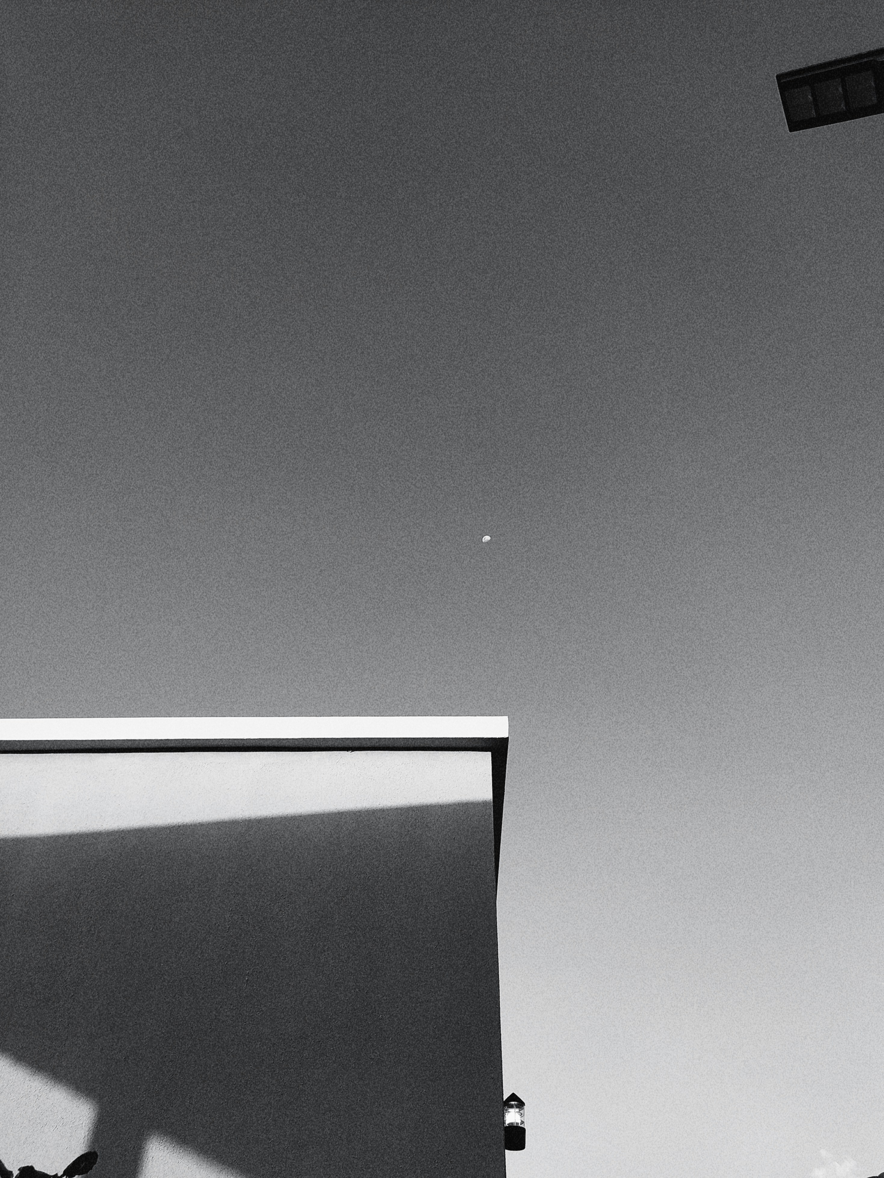 a black and white photo of a wall with a light on it