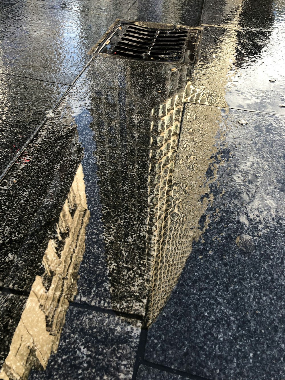 a sidewalk with a puddle of water