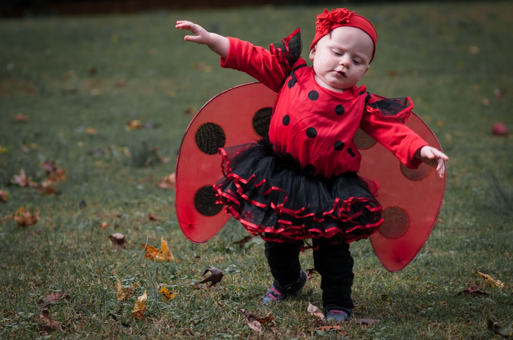 a child wearing a red coat and holding a red and black object