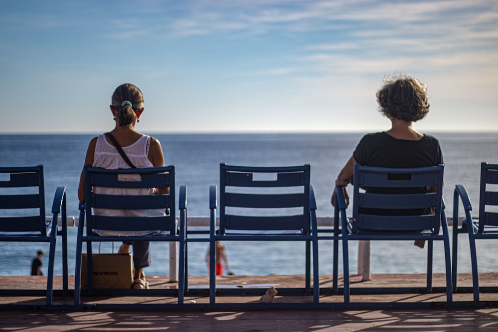 a couple of people sitting on chairs at a beach