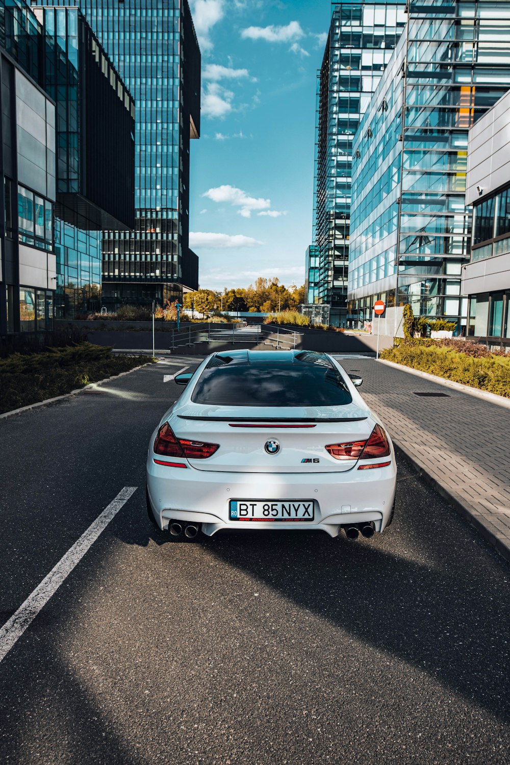 a white car parked in a parking lot between buildings