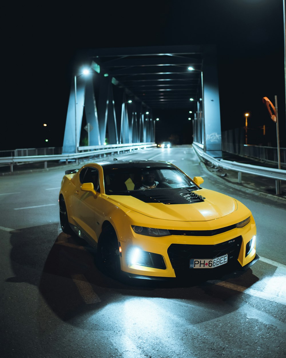 a yellow sports car on a road