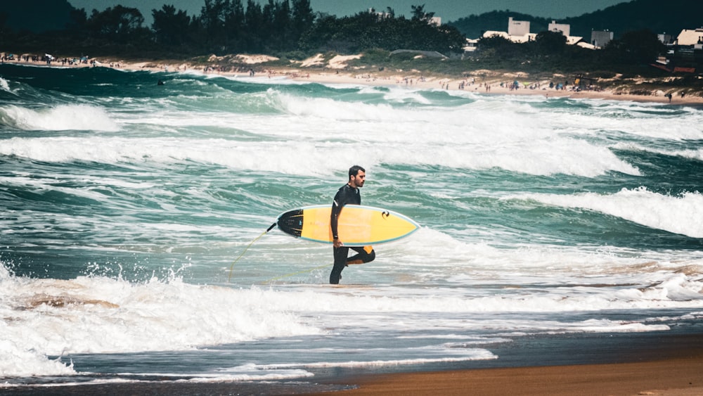 a man carrying a surfboard on a beach