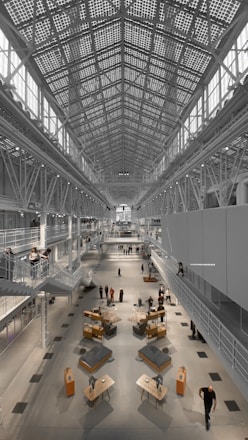 An elegant event hall filled with visitors exploring luxury property displays.