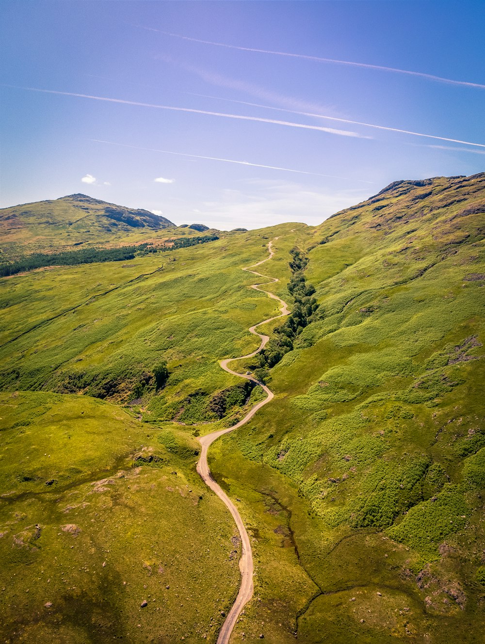 a stream running through a grassy area with Quiraing in the background