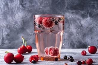 a glass of water with berries