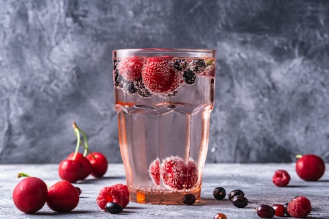 a glass of water with berries