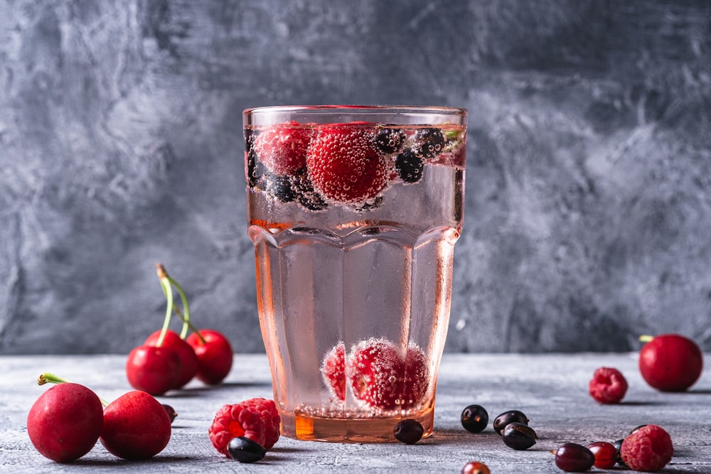a glass of water with berries