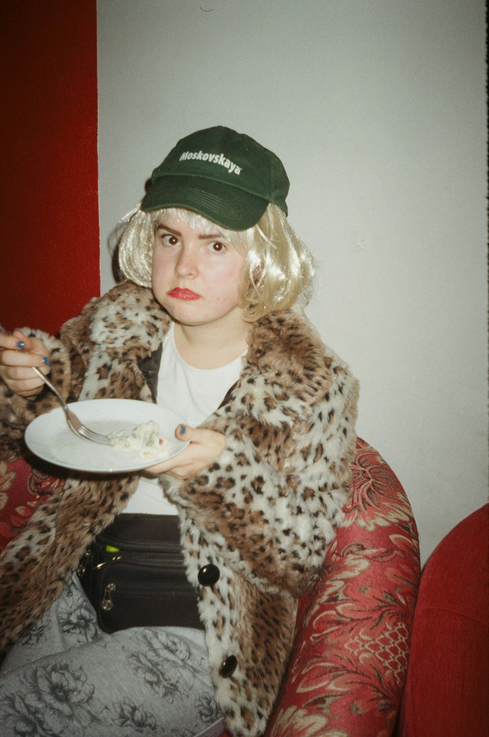 a person in a hat holding a plate of food