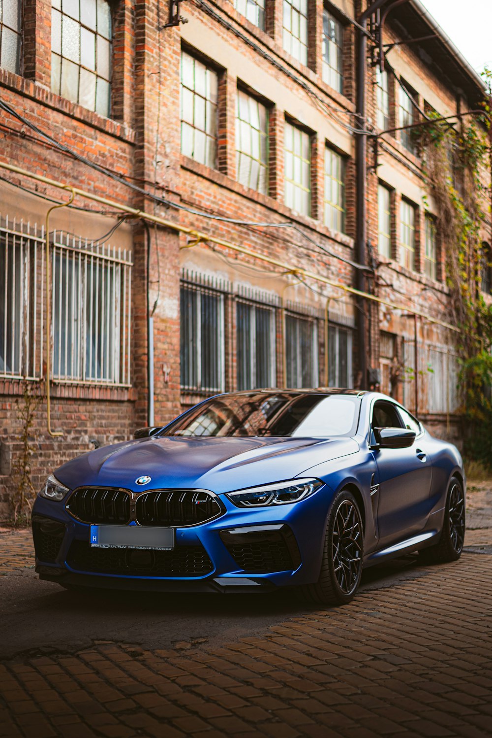 a blue car parked in front of a brick building