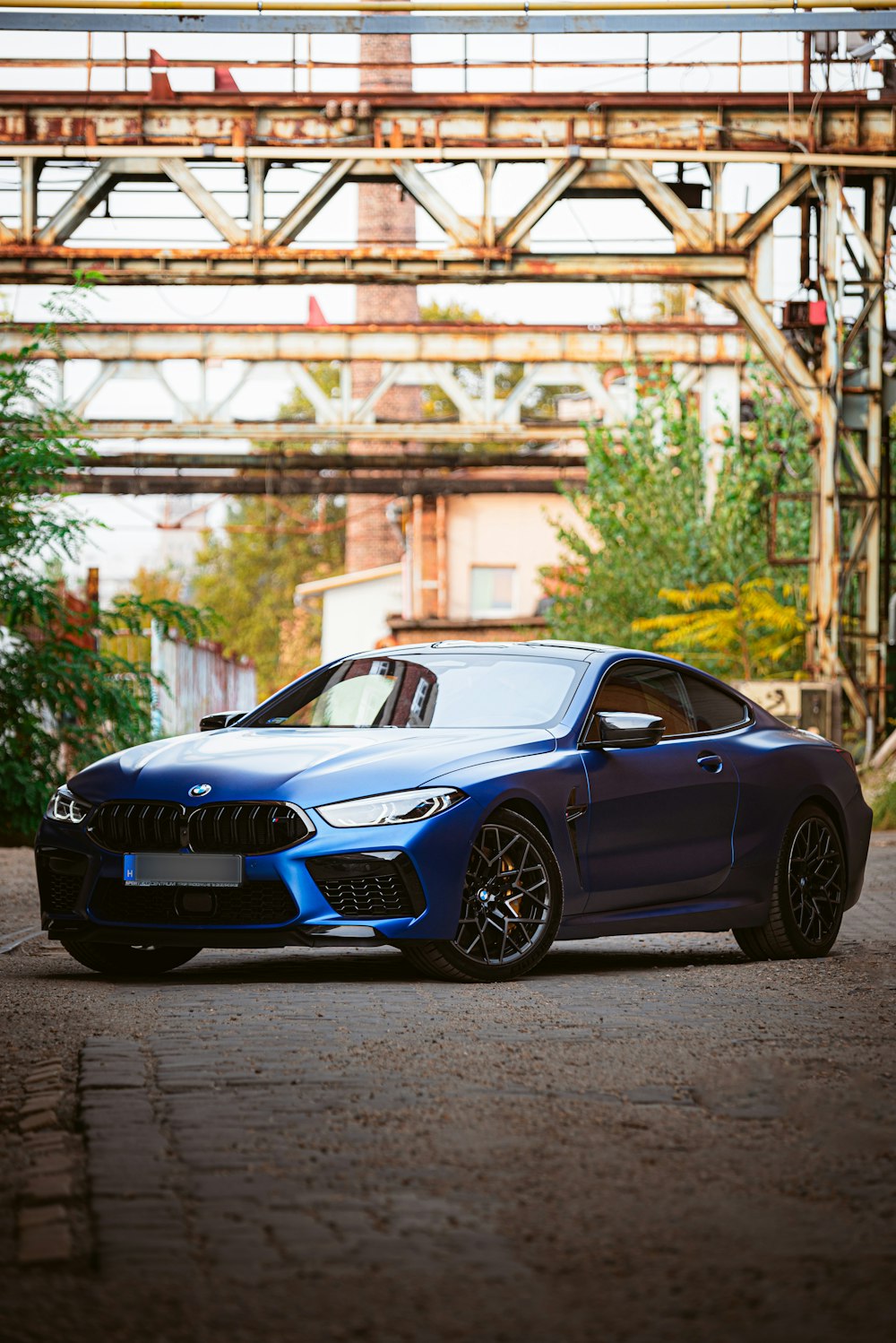 a blue car parked under a bridge