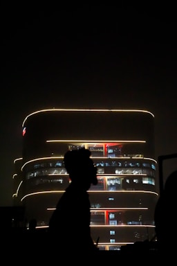 Night view of a mixed-use building illuminated with soft lights.