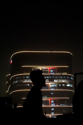 Night view of a business complex illuminated with soft yellow lights against a dark facade.