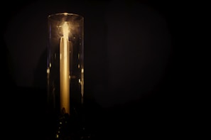 A sleek candle casting warm light over a minimalist workspace, inspiring focus and clarity.