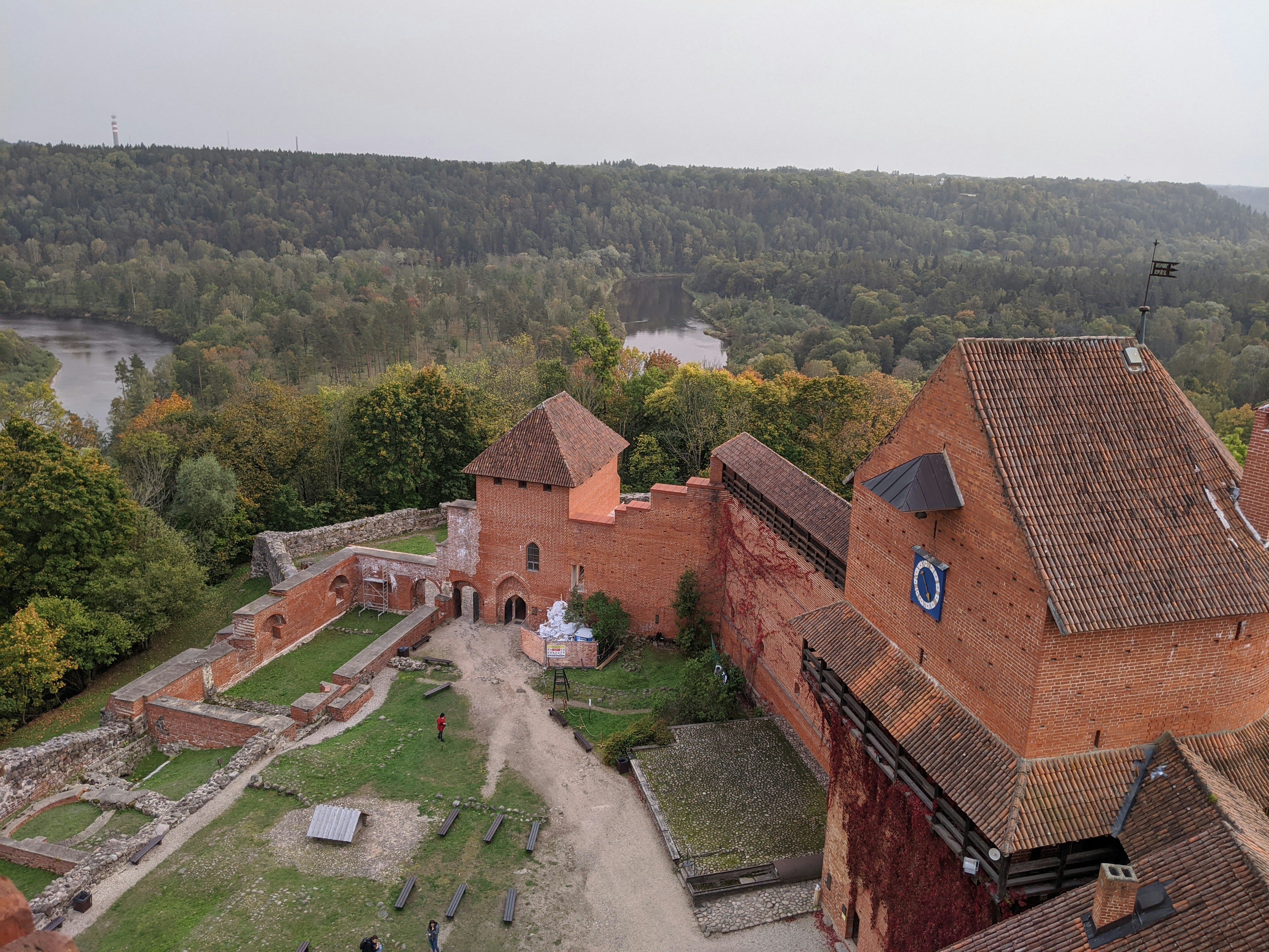 a group of buildings with trees and a river in the background