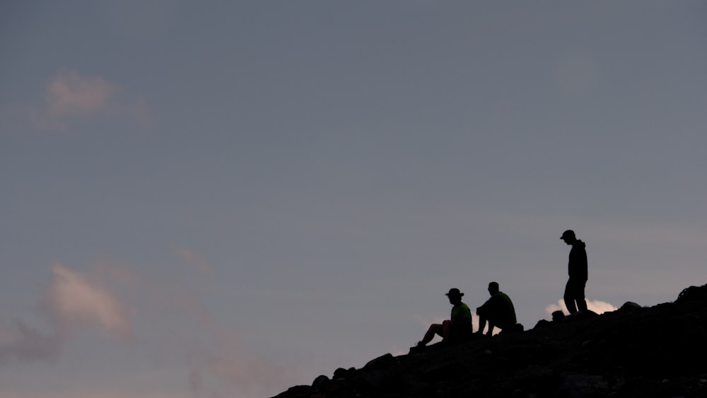 a group of people sitting on a rock