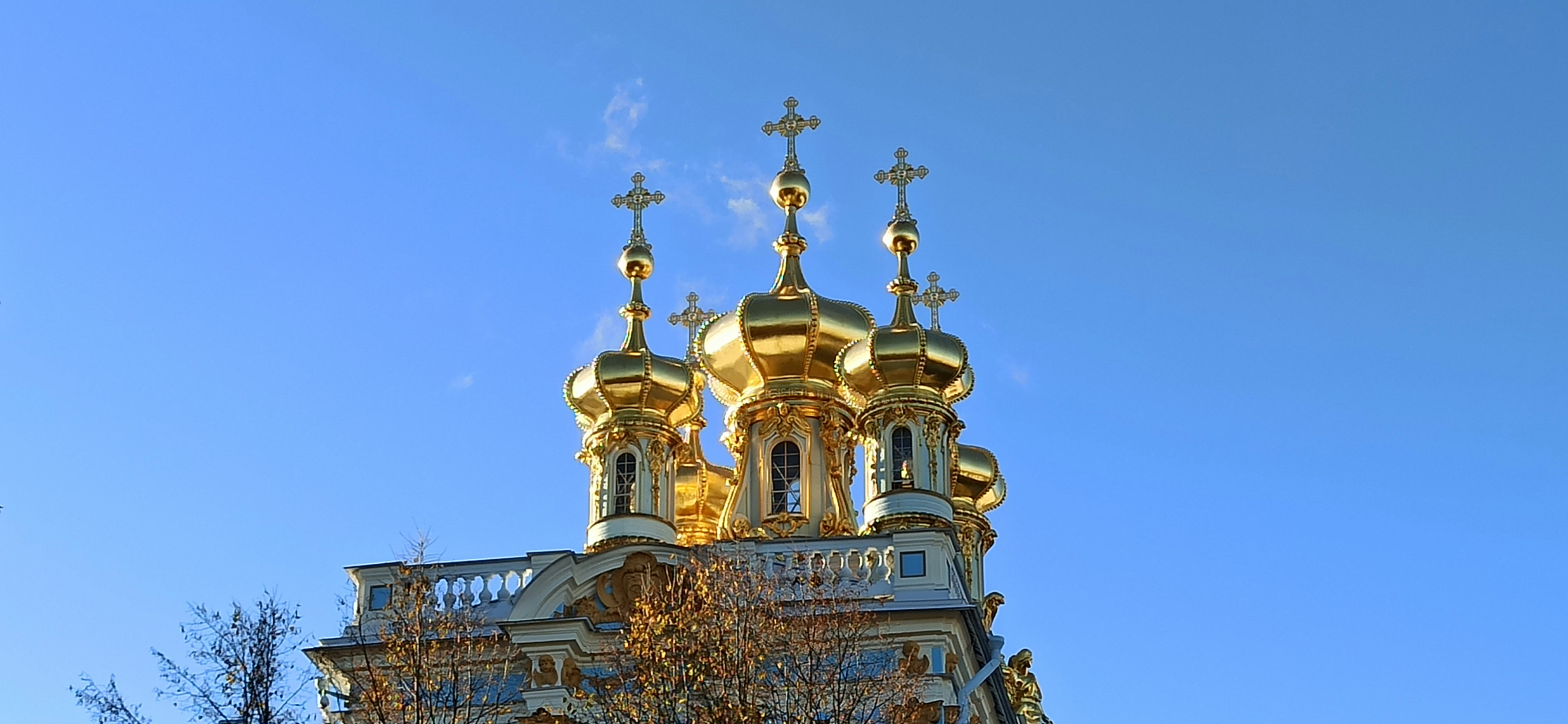 a building with a gold roof and crosses on top