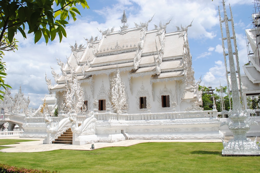 a white building with a grass lawn