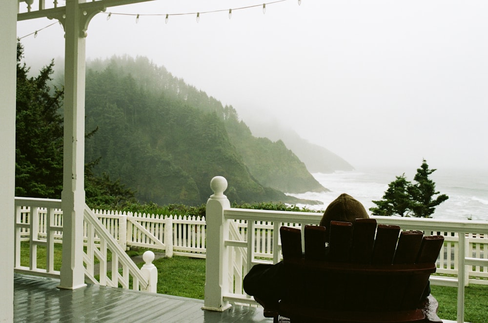 a white railing with a white railing and a body of water in the background