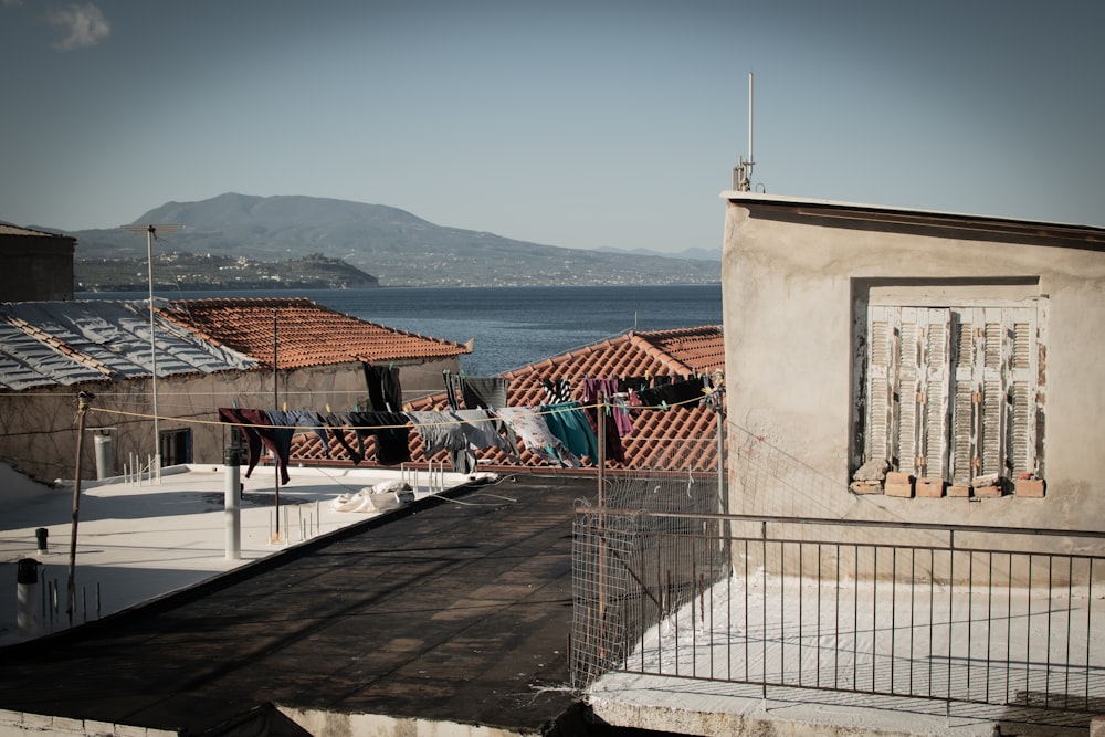 a building with a fence and a body of water in the background