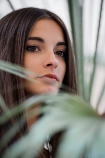 Soft-focus image of a woman meditating outdoors surrounded by greenery, embodying wellness