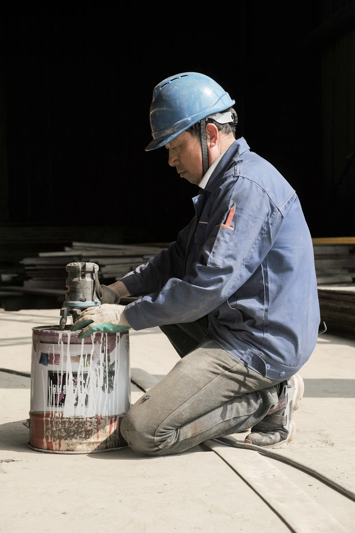 a man wearing a hard hat and holding a metal container