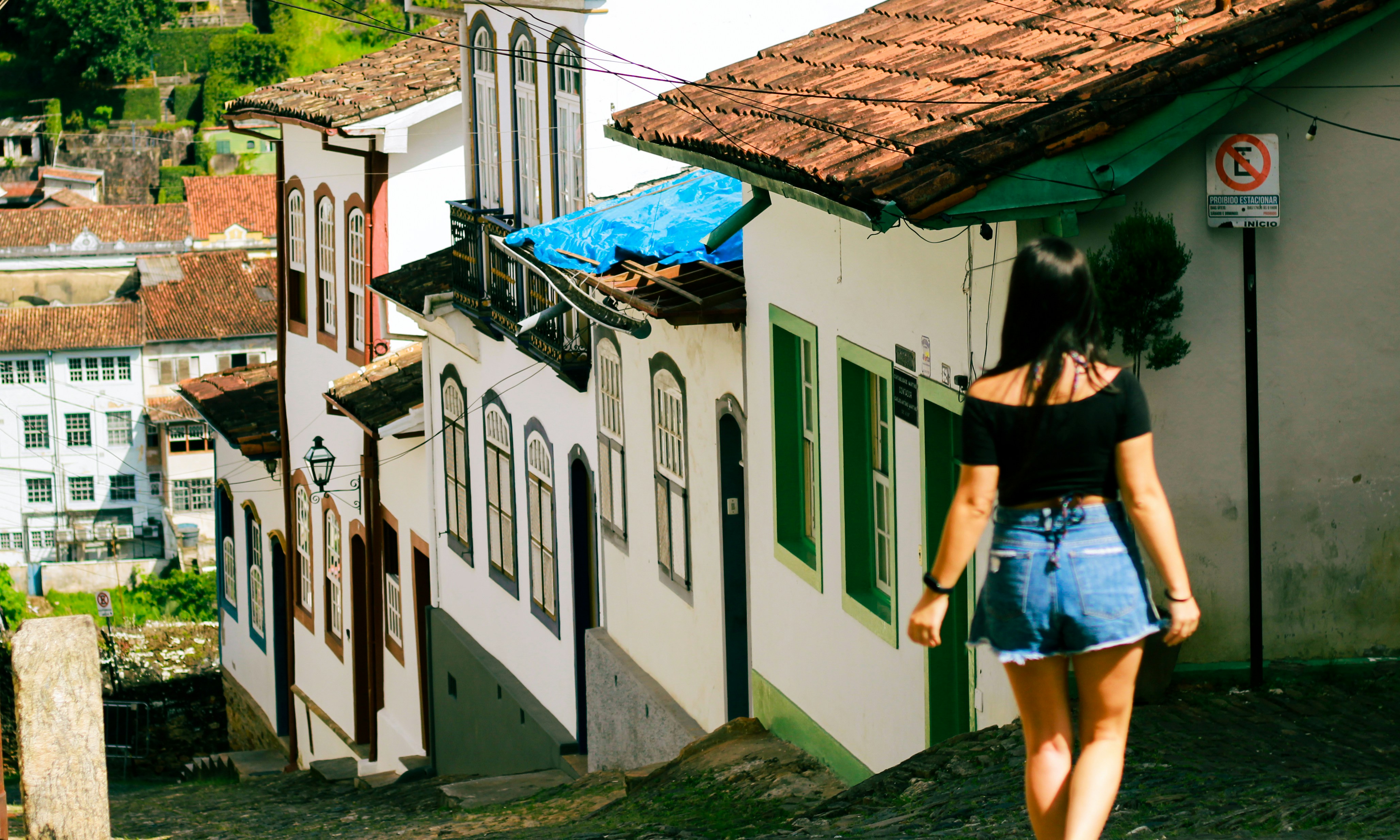 Woman walking up a cobblestone street in historic town