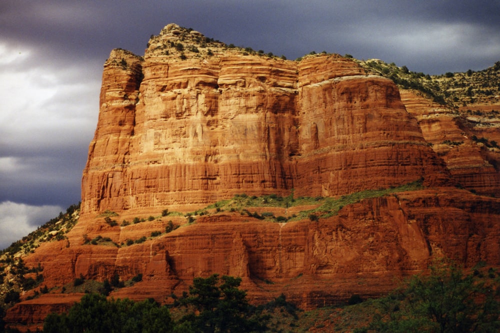 a large rocky cliff with Mehrangarh Fort in the background