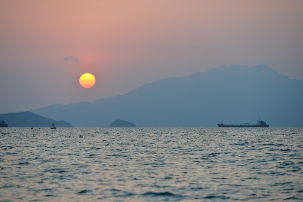 a body of water with boats in it and a mountain in the background