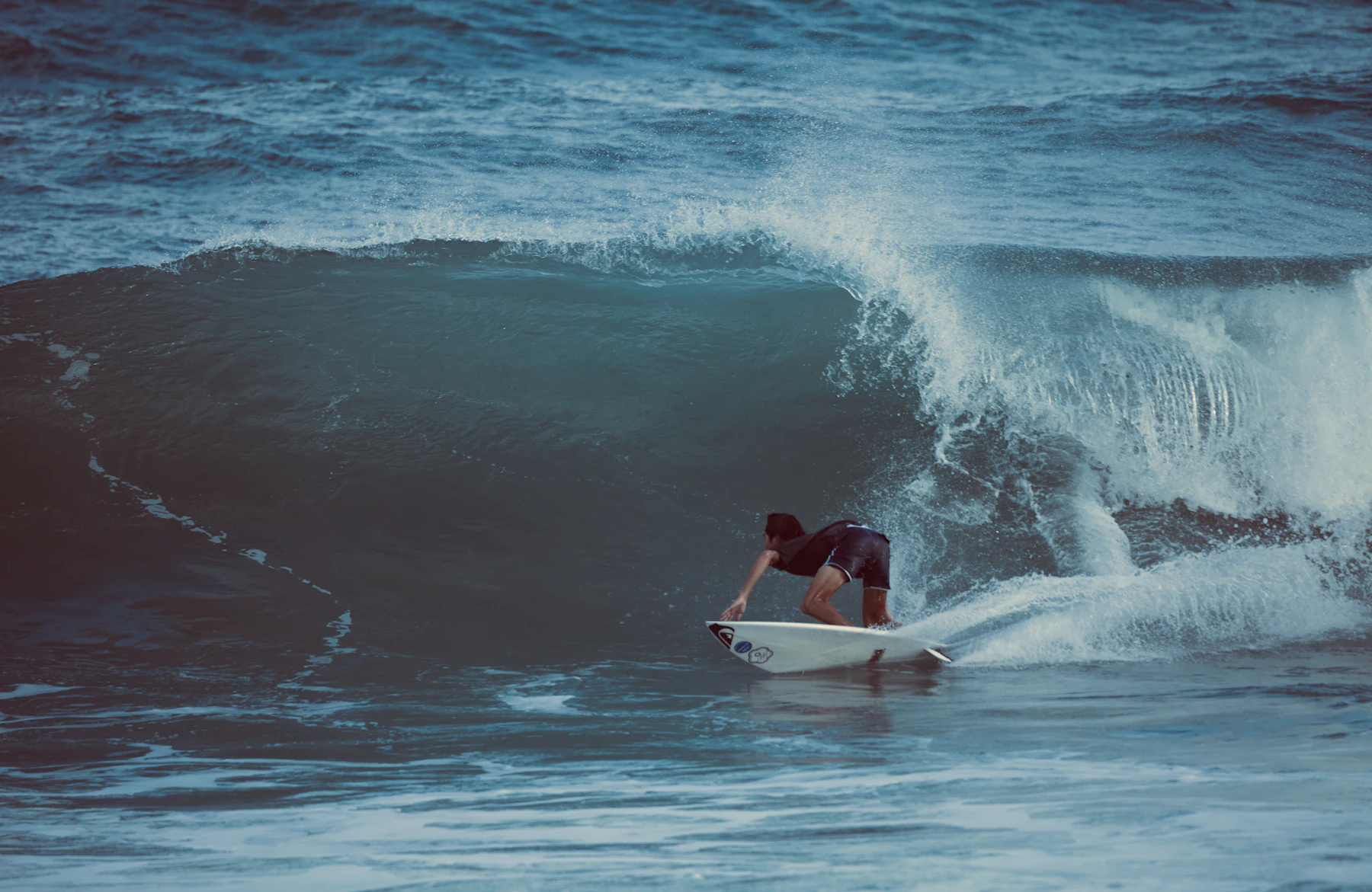 Surfer riding across the face of an ocean wave
