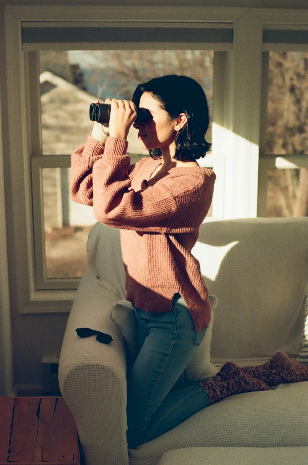 a woman sitting on a couch and holding a camera