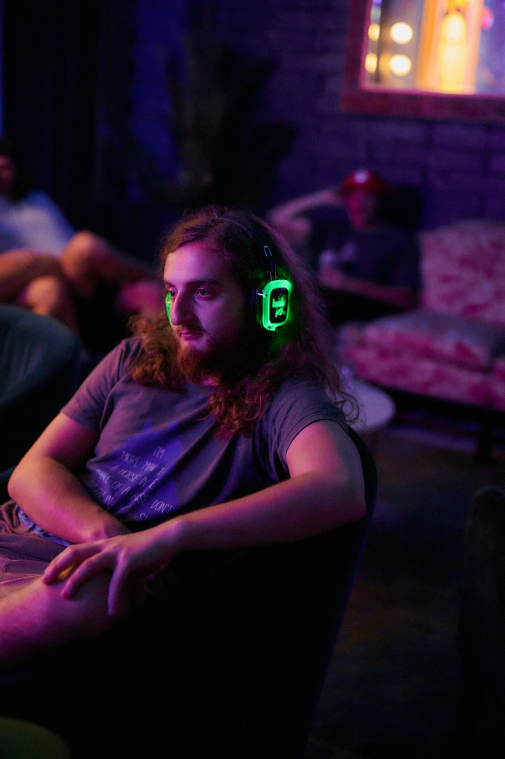 a person with a green light on the face sitting on a couch