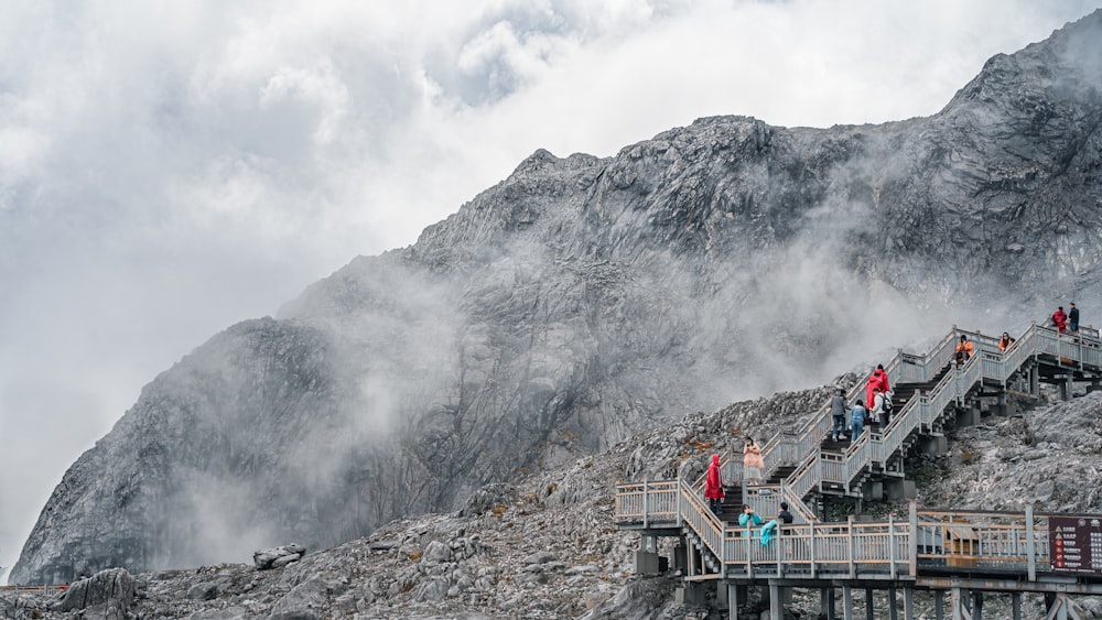 a group of people on a bridge over a mountain