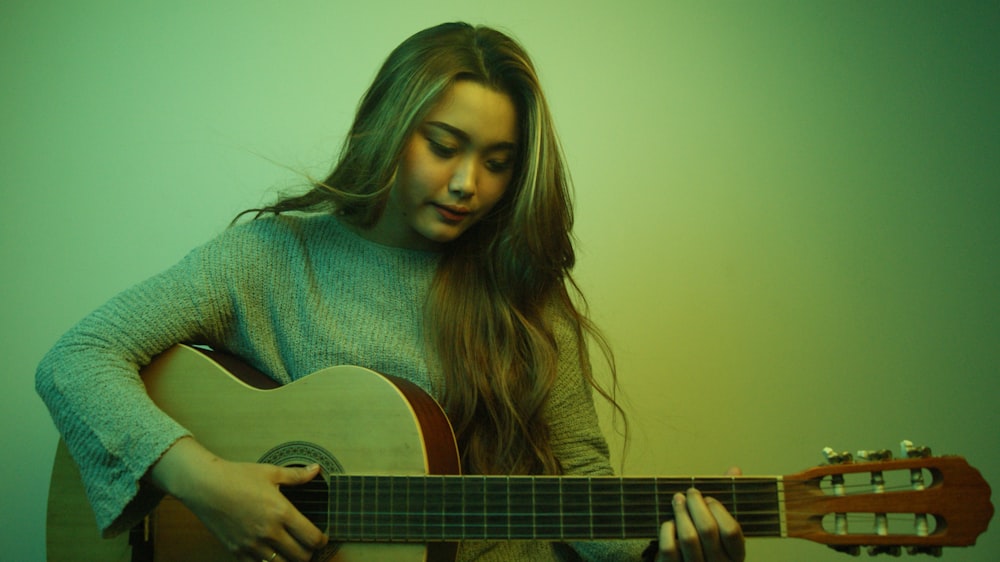 a woman playing a guitar