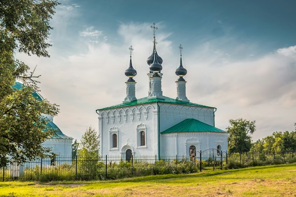 A white church with green onion domes — Suzdal, Russia