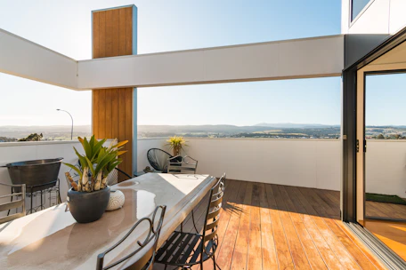 a table with chairs and plants on it by a window