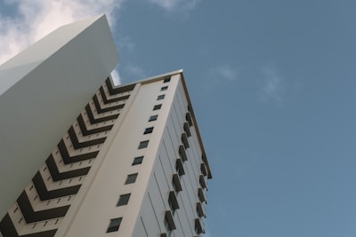 Modern high-rise building exterior with clear architectural lines under a deep blue sky.